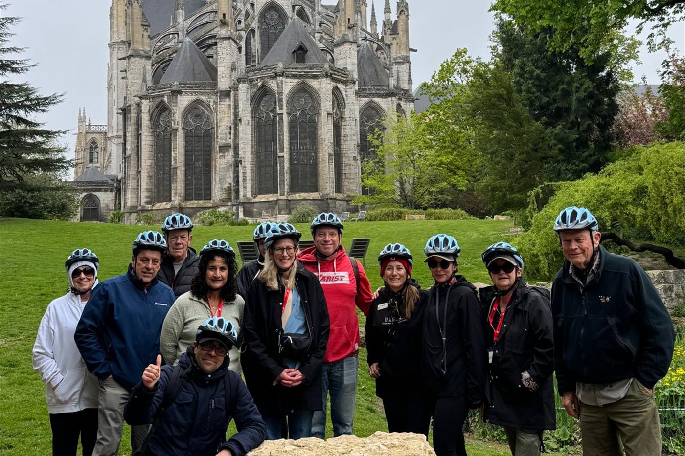Guests in cycling helmets outside a Gothic cathedral