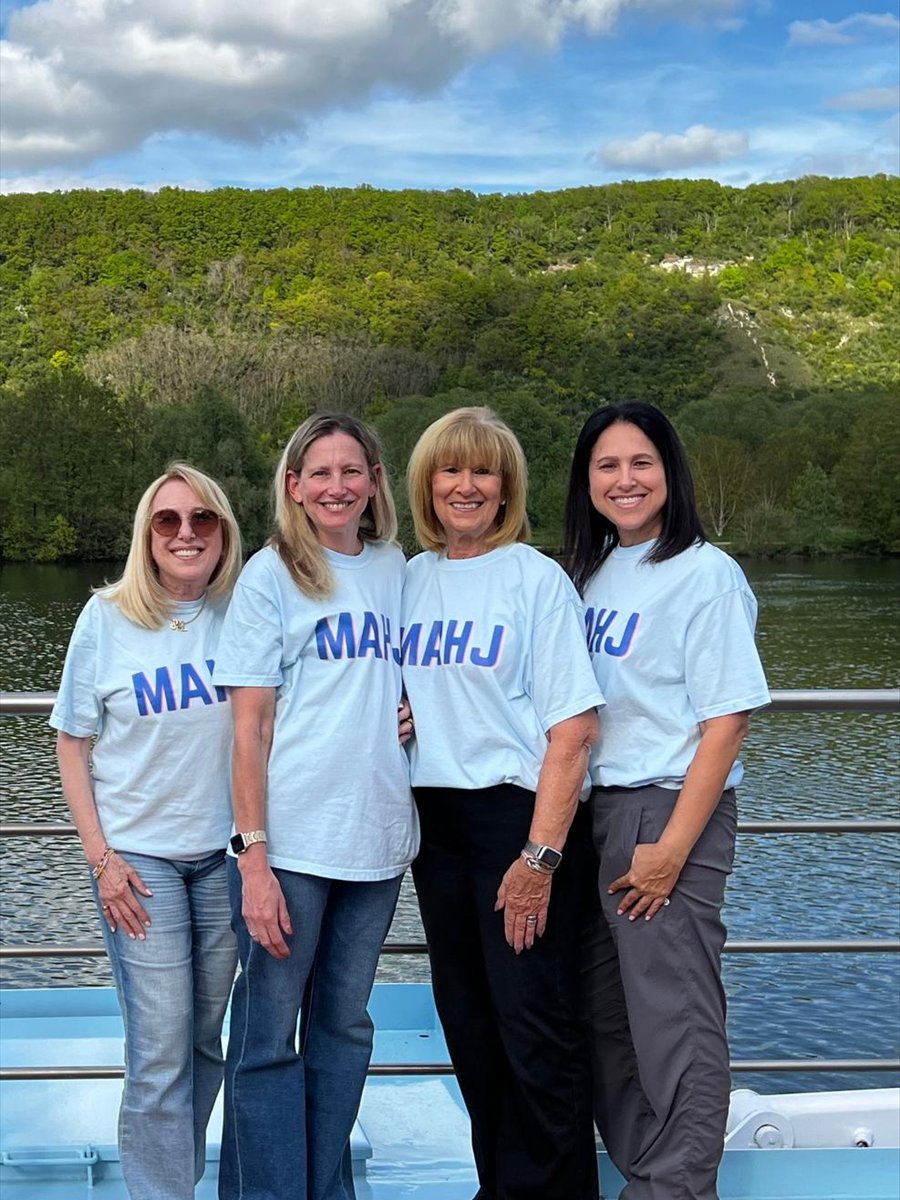 Four friends in matching Mah Jongg shirts on the ship deck